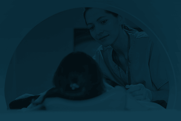 A doctor checking on a patient lying in an MRI machine.