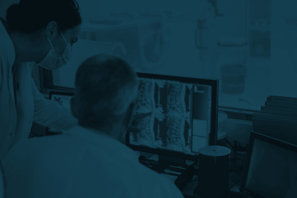 Two doctors reviewing test results on a monitor.