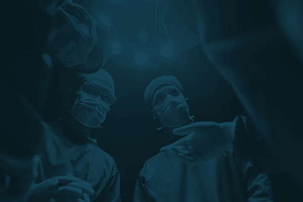 The view from a patient looking up at a team of healthcare professionals standing around them in an operating room.